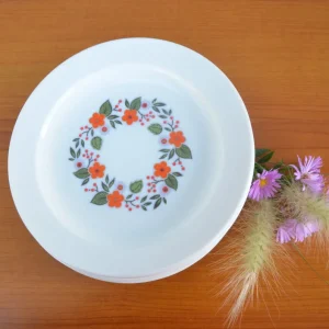 Lot de 7 assiettes à dessert, Arcopal. Motif central de fleur orange et grise.